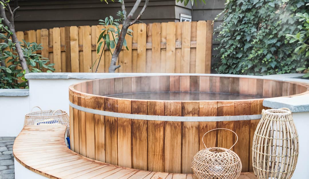 Steamy outdoor wooden hot tub on patio